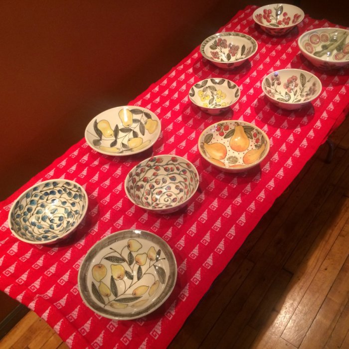 Table with red tablecloth with printed, ceramic dishes on it